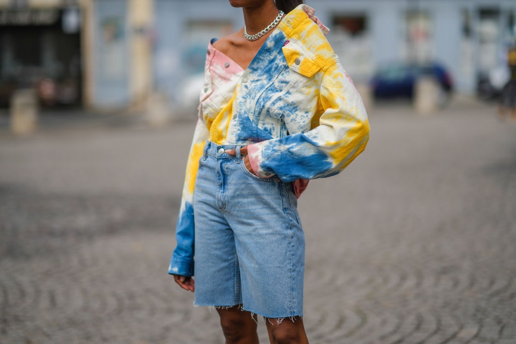 Emilie Joseph in a colourful dye denim jacket by Levis and blue faded denim jean dad shorts in Paris, France. Photo by Edward Berthelot/Getty Images