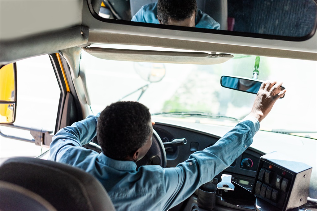 Driver who transports children to and from school adjusting back view mirror. Picture: istock