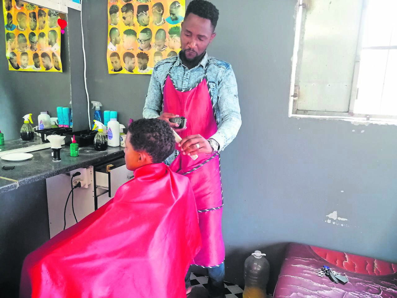 Cassiem Ndabazaniye cuts a young boy’s hair as part of the give dignity initiative.PHOTO: supplied