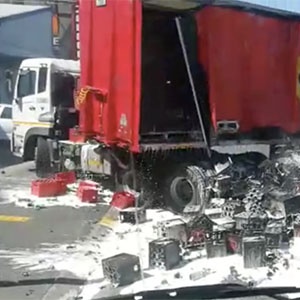 A truck transporting beer, loses it's load as it attempts to make a turn.
