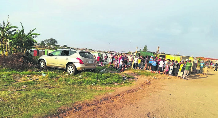 Curious onlookers at the scene where taxi boss Solomon Zulu was murdered on Wednesday. 