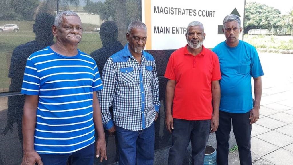 From left to right: Jones Naicker (Regan Naidoo's grandfather), Siva Mudley (a family friend), Timothy Naidoo (Regan's father) and Jeffery Mahalingan (Regan's uncle) are seen outside the Durban Magistrate's Court. The trial of 18 police officers for his death in custody has again been postponed. (Benita Enoch/GroundUp)