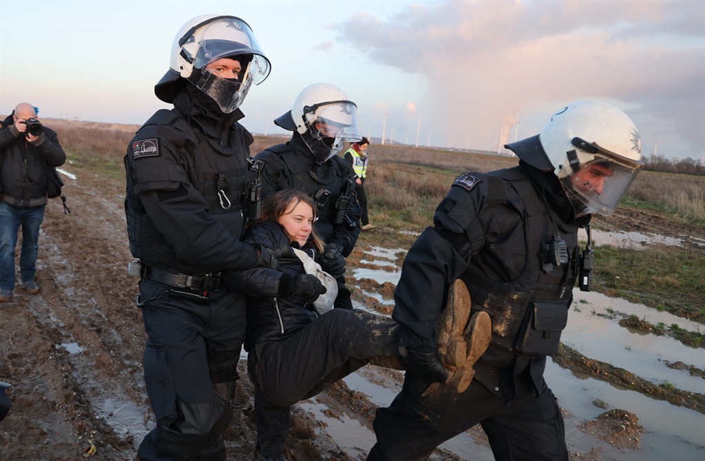 Police officers carry Swedish climate activist Greta Thunberg out of a group of demonstrators and activists in Erkelenz, western Germany. (Photo: Christoph Reichwein / dpa / AFP)