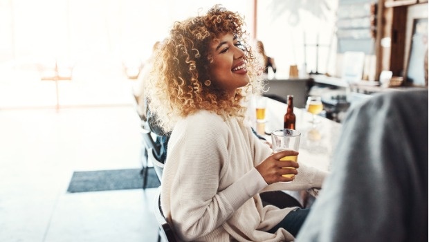 A woman drinks a beer
