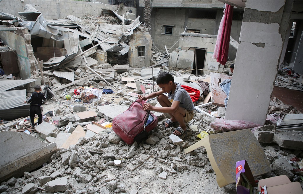 Palestynse kinders soek Saterdag deur die puin van ’n huis in Rafah wat in ’n Israeliese lugaanval vernietig is. Foto: Reuters