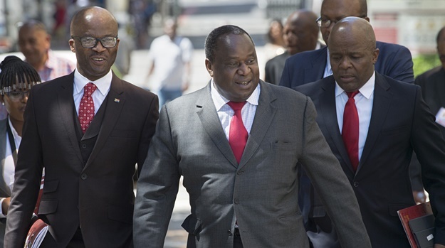 Finance Minister Tito Mboweni walks with members of the Treasury to deliver his mini budget speech. (Rodger Bosch/AFP)