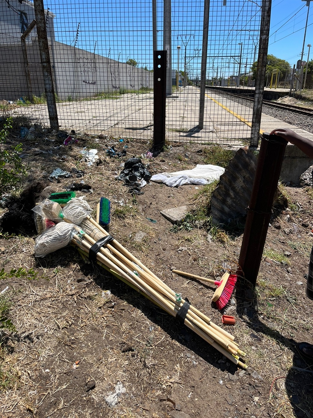 Tied up bundle of brooms on ground near railway li