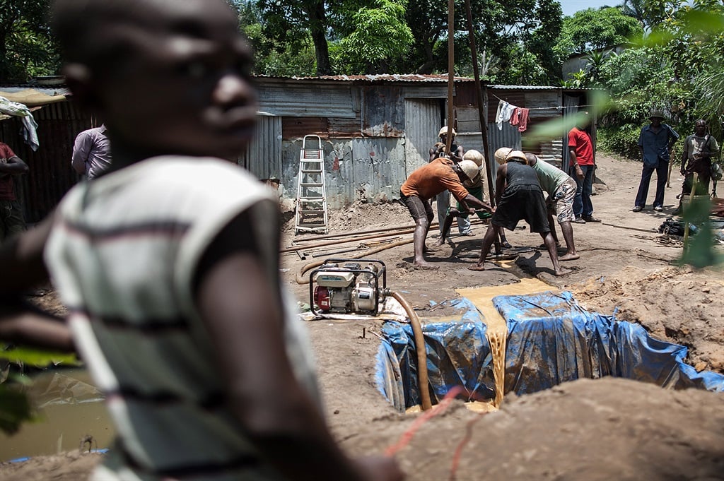 Workers sink a borehole using a manual drill at a village in the west districts of Kinshasa, DRC, so that women and children do not have to walk long distances to reach small and often polluted river on 7 March 2015. (Federico Scoppa / AFP)
