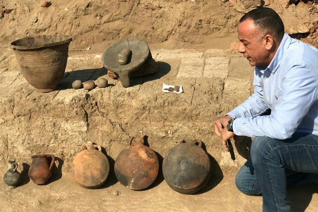 Mostafa Waziri, the head of Egypt's Supreme Council of Antiquities, sitting next to artefacts discovered at an excavation of an 1,800-year-old "complete residential city from the Roman-era."