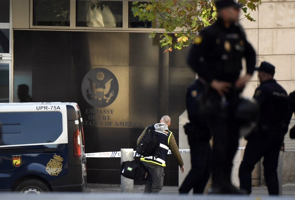 Spanish police stand guard near the US embassy in Madrid after they received a letter bomb.