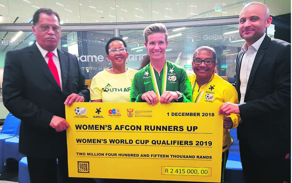 HERO'S WELCOME From left: Safa president Danny Jordaan, Sports Minister Tokozile Xasa, Banyana Banyana captain Janine van Wyk, Banyana head coach Desiree Ellis and Sasol vice-president of group communication and brand management Elton Fortuin display the R2 415 000 cheque that the Banyana team will share
