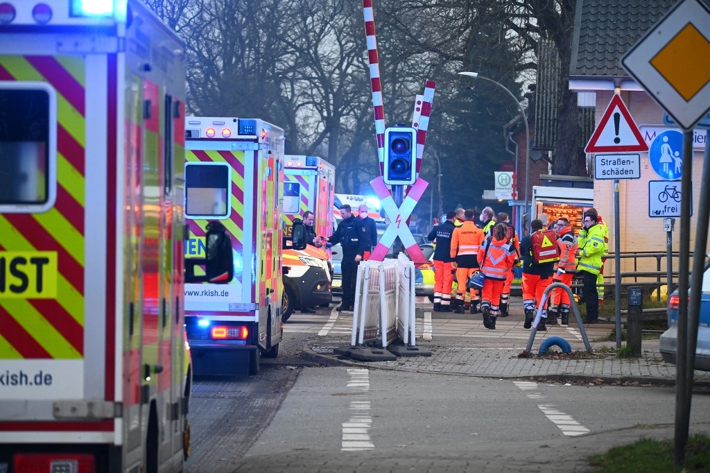 Rescue teams, ambulances and police stand at a railway crossing at the station of Brokstedt, northern Germany, on January 25, 2023, after a man stabbed people on a regional train between the cities of Hamburg and Kiel.