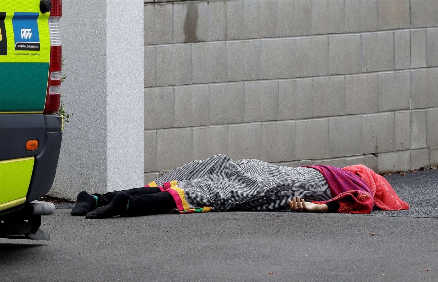 A body lies on the footpath outside a mosque in central Christchurch, New Zealand, on Friday (March 15 2019). A witness says many people have been killed in a mass shooting at a mosque in the New Zealand city of Christchurch. Picture: Mark Baker/AP