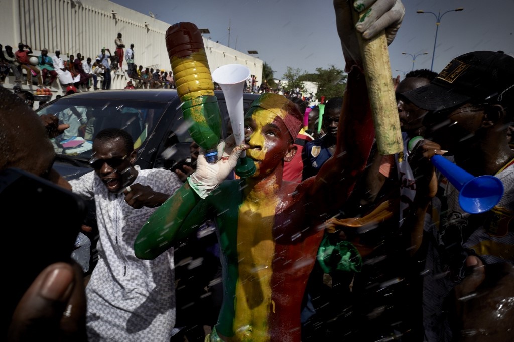 A man painted in the colours of the Malian flag gestures at Independence square as protesters gather to demand that Malian President Ibrahim Boubacar Keïta leaves office in Bamako on June 19, 2020.