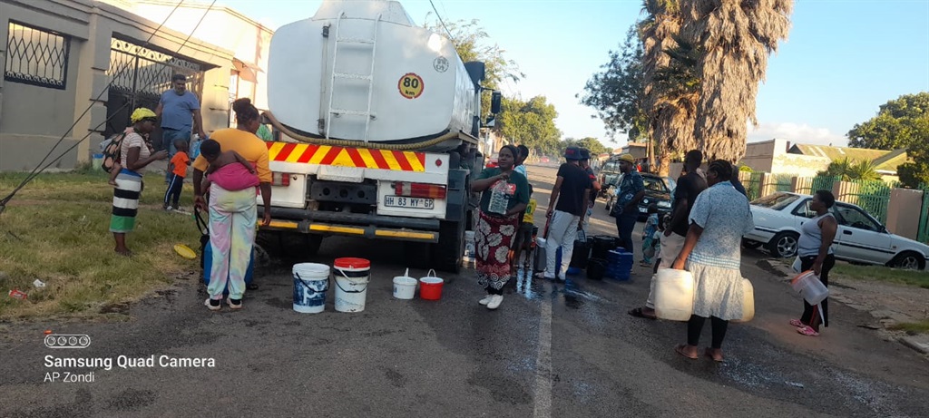 Residents in Crosby, Johannesburg, fetch water from a tanker on Lismore Ave on Monday.