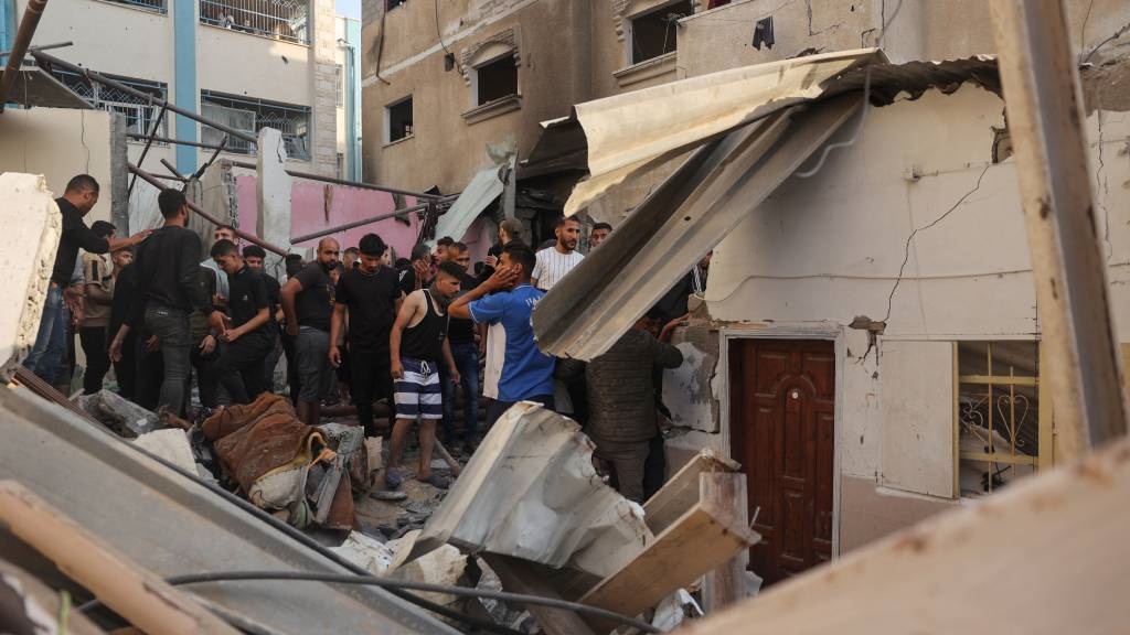 Palestinians search for casualties in the rubble of a house destroyed in an Israeli strike in the centre of Rafah in the southern Gaza Strip, amid the ongoing conflict between Israel and the Palestinian Hamas movement. (AFP)