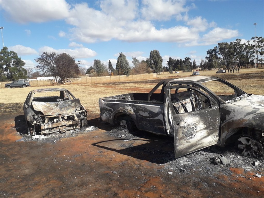 The smouldering shells of two cars that were set alight outside the IPHC headquarters in Zuurbekom where five people died in a hostage drama on Saturday. 