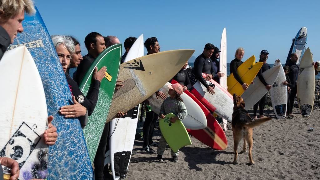Surfers stand before taking part in a ceremony in 