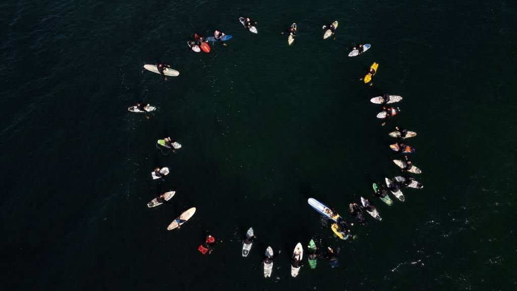 This is an aerial view of surfers taking part in a ceremony in honour of an American and two Australians surfers who went missing during a surfing trip at San Miguel Beach in Ensenada, Baja California State, Mexico. (Guillermo Arias/AFP)