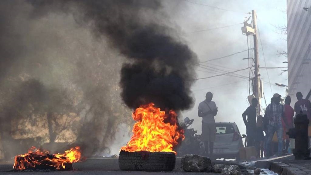 This screen grab taken from AFPTV shows tires on fire near the main prison of Port-au-Prince, Haiti, after a breakout by several thousand inmates. At least a dozen people died as gang members attacked the main prison in Haiti's capital, triggering a breakout by several thousand inmates, an AFP reporter and an NGO said. (Luckenson Jean/AFPTV/AFP)