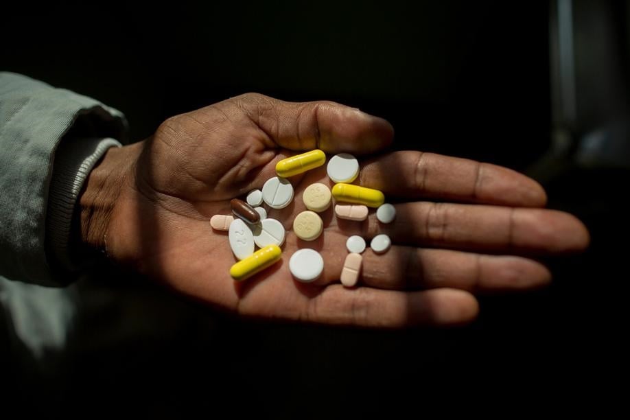 A TB patient holds an array of medication for XDR-TB. 