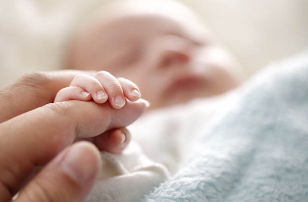 Gently place your finger in the palm of baby's hand and they’ll close it around your finger.