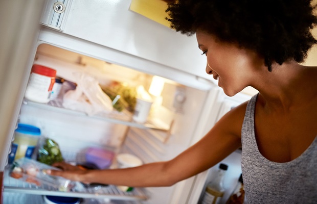 Woman putting food in fridge 