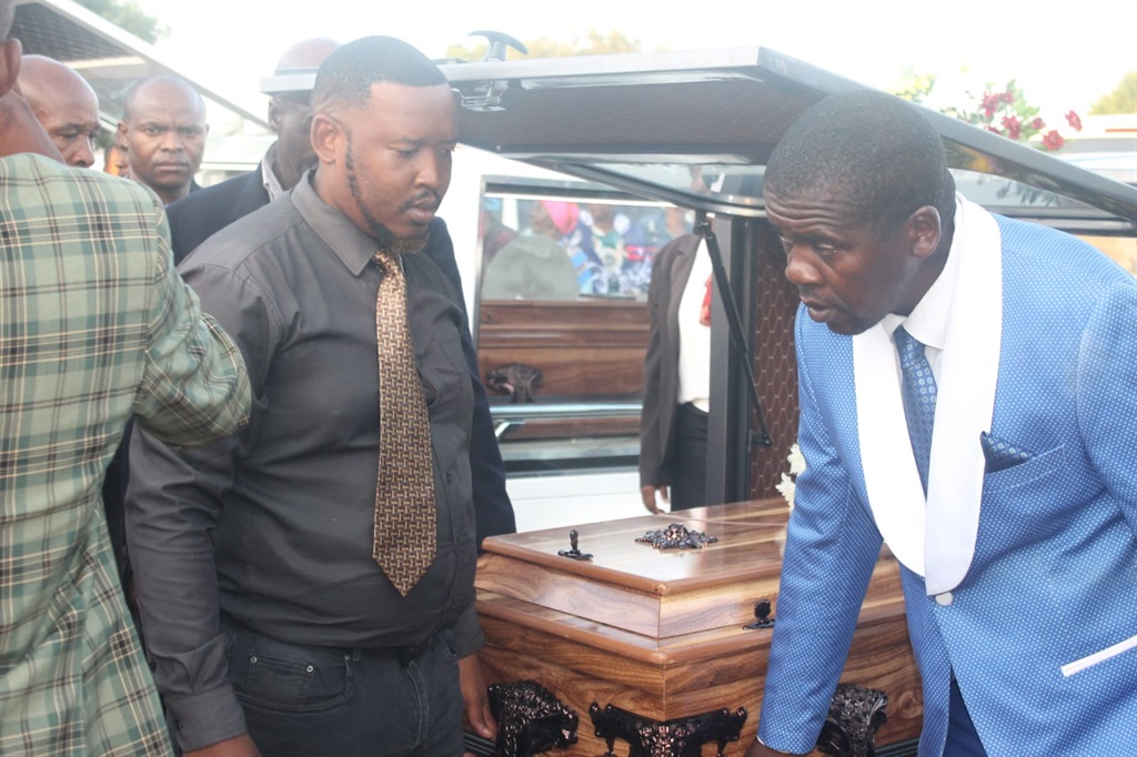 Pallbearers and family members carrying one of the coffins. Photo by Thokozile Mnguni