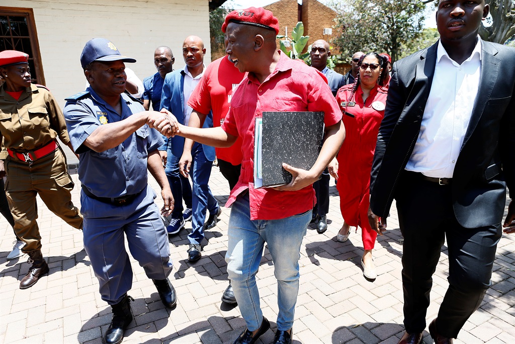 EFF leader Julius Malema is greeted by a police official as he arrives at the Brooklyn Police Station to open a criminal case involving money laundering, corruption, racketeering, fraud and perjury against Public Enterprises Minister Pravin Gordhan and his daughter Anisha Gordhan on Tuesday. Picture: Phill Magakoe/Gallo Images