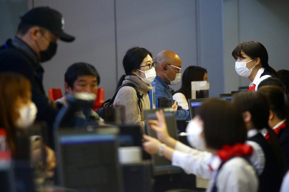 Passengers wearing protective mask following an outbreak of the coronavirus disease check in at Kansai International Airport in Osaka, Japan. Picture: Edgard Garrido/Reuters
