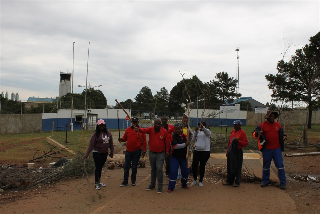 A group of National Union of Mineworkers members outside the South Shaft entrance at South Deep where they had barricaded the entrance with rocks, logs and branches.