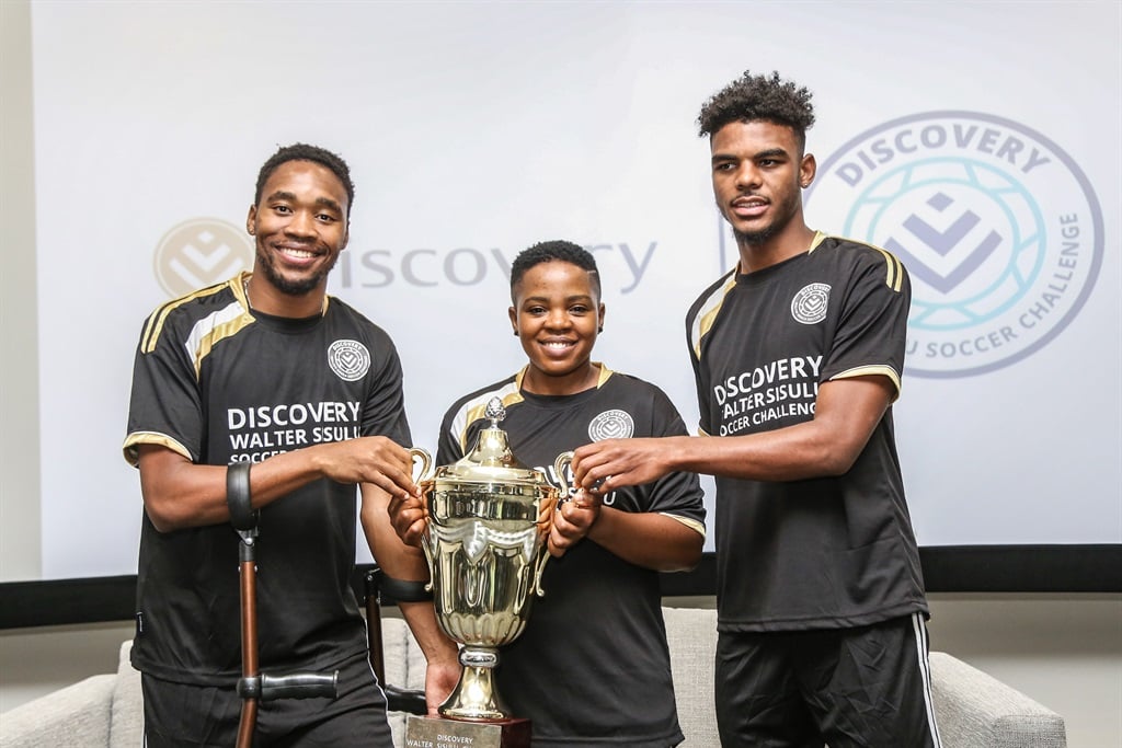 Sibusiso Vilakazi of Mamelodi Sundowns, the under-17 national coach Simphiwe Dludlu and Lyle Foster of Orlando Pirates with the Discovery Walter Sisulu Soccer Challenge trophy.PHOTO: Supplied