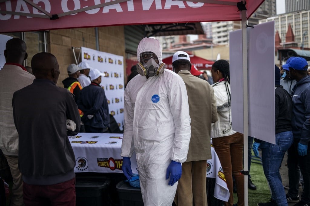 An employee of a South African company specialised in sanitisation wears a full protective suit while at the Wanderers taxi rank in Johannesburg. (Michele Spatari, AFP)