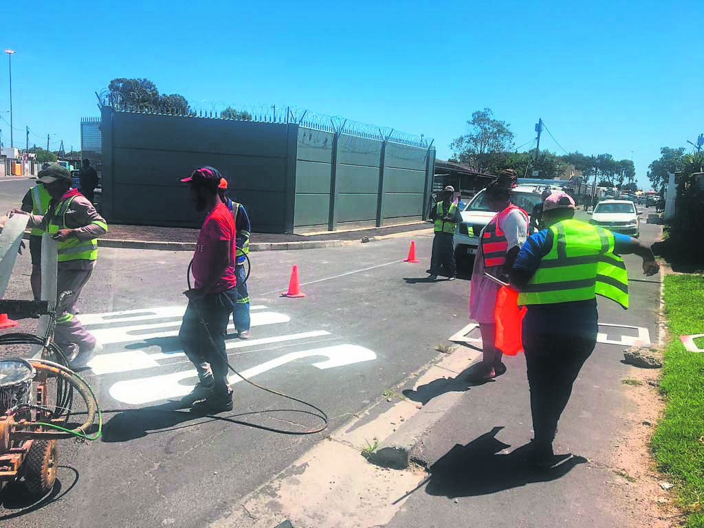 The City of Cape Town contractors are working around the clock to fix roads in Ward 38. Local councillor Suzanne Zumana (wearing an orange dress and bib) is keeping an eye on the progress.