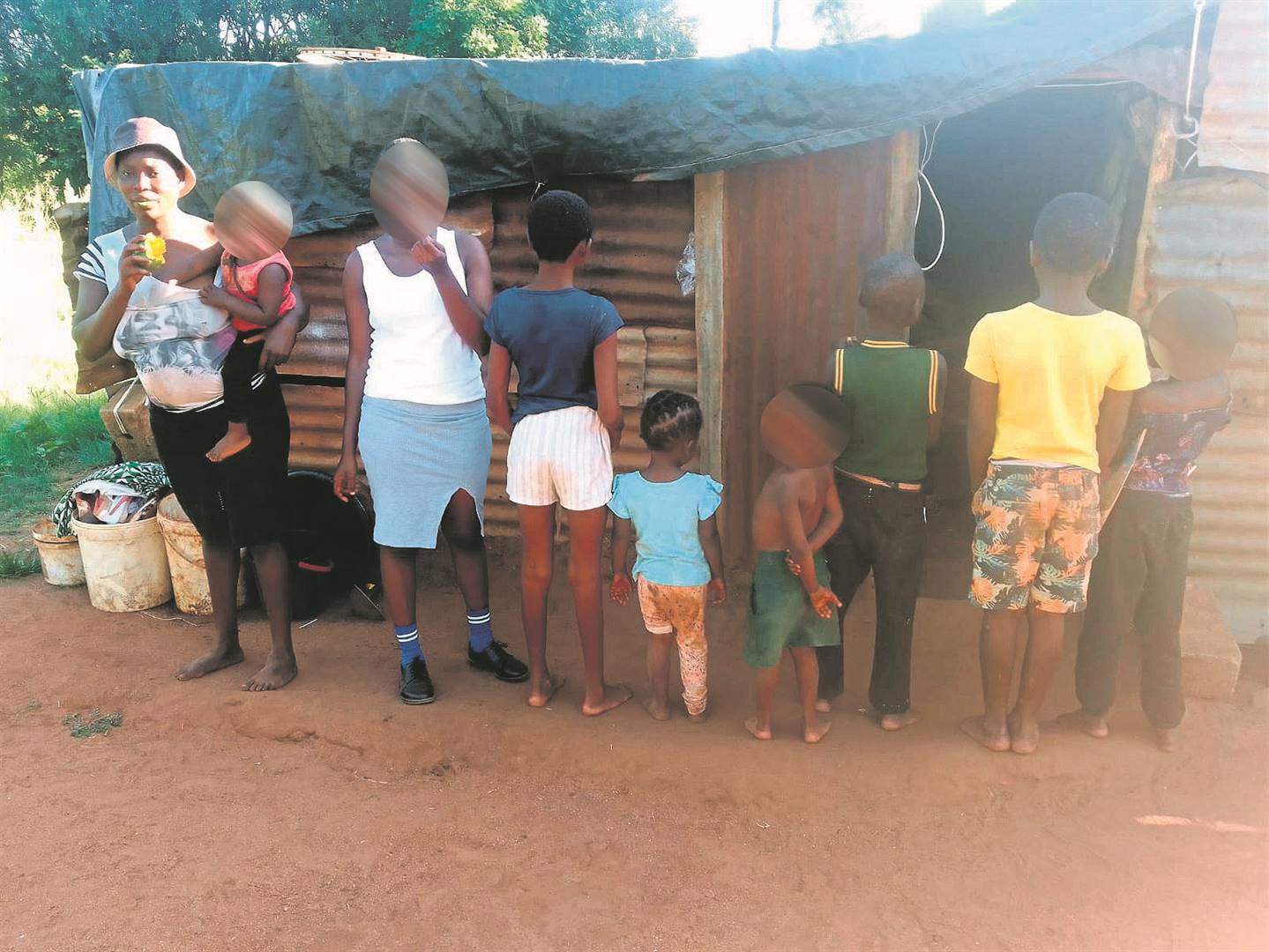 The family members outside their zinc shack. Photo by Oris Mnisi