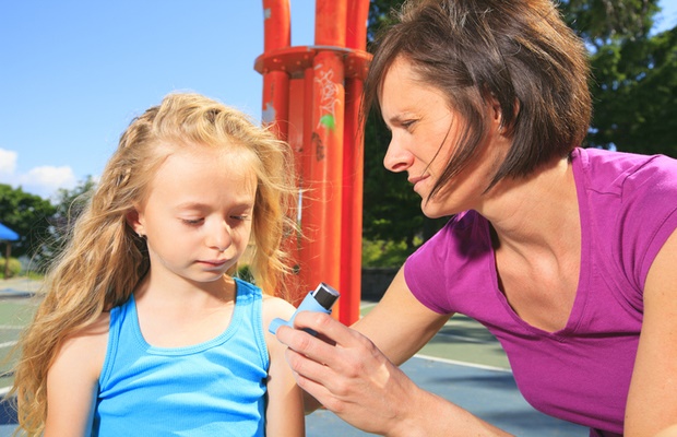 Mother teaching child how to use inhaler 