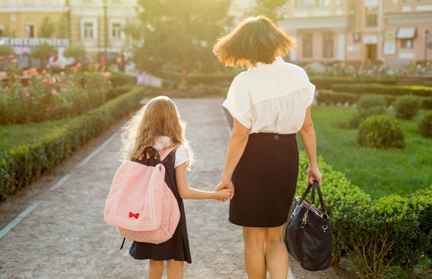 Mother walking her daughter to school 