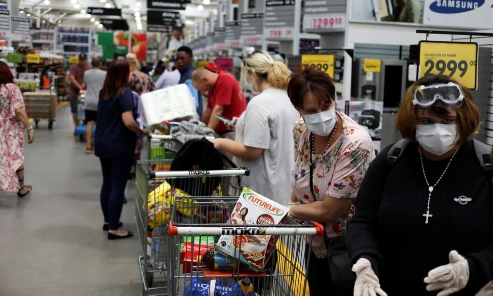 Shoppers stock up on groceries as they wear protective masks to contain coronavirus at a Makro store in Johannesburg. Picture: Siphiwe Sibeko/Reuters