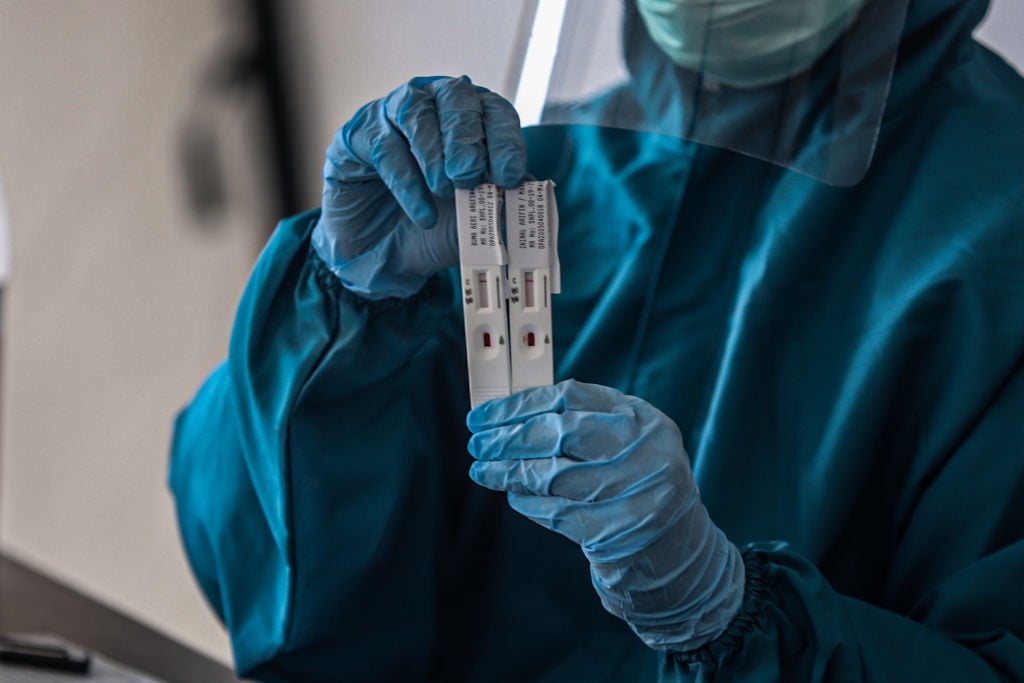 A health worker about to process a Covid-19 test kit. 