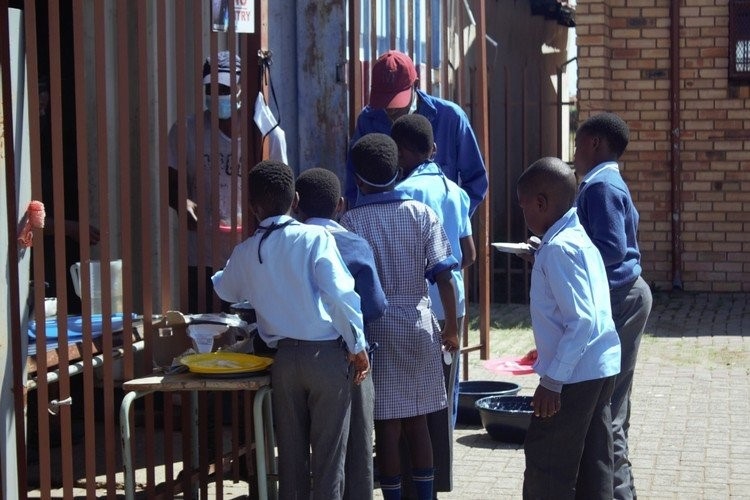 Learners at Rivoningo Primary School in Soshanguve, Pretoria queue for one of the meals they are given at school. For many of the learners, this is the only meal they will get for the day.