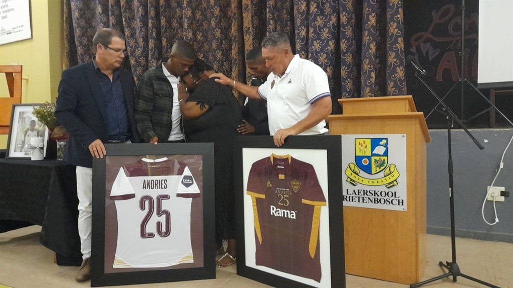 Stellenbosch FC CEO Rob Benadie and coach Steve Barker comfort Oshwin's mother Natasha as she broke into tears during the handover of Oshwin's jersey. Photo by Lulekwa Mbadamane
