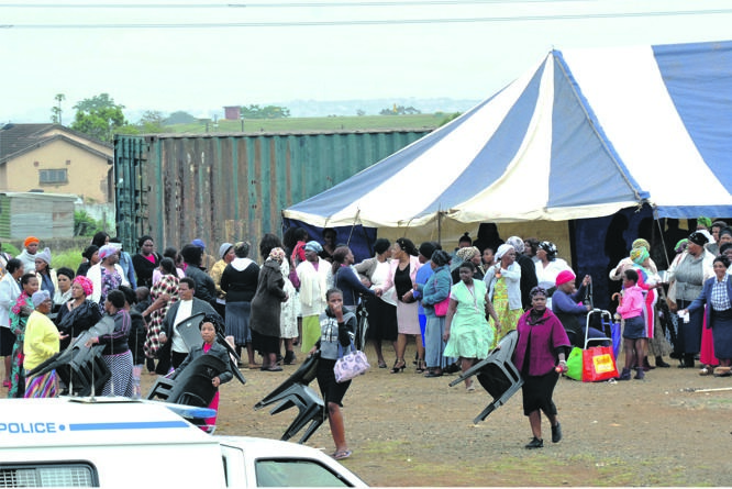 Church members are seen packing their chairs and tent after community members ordered them to vacate the land voluntarily or be forced to do so