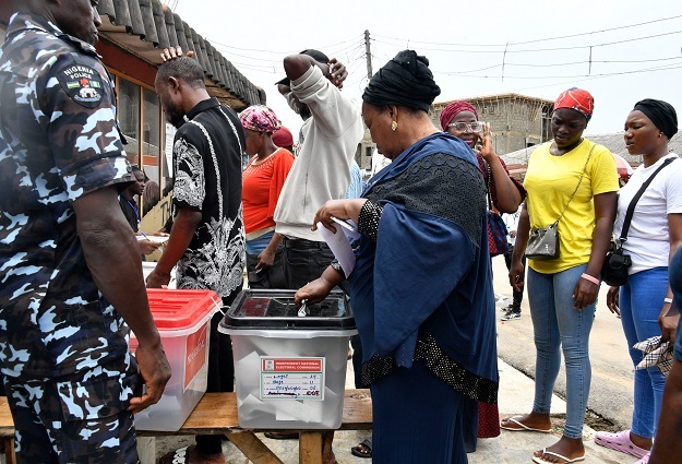 A voter casts her ballot at a polling station during local elections, in Lagos, on 18 March.
