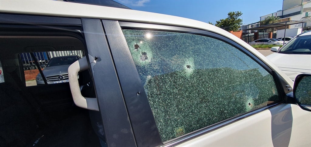 A close-up view of the gunshots that penetrated the driver's side window and pillar.