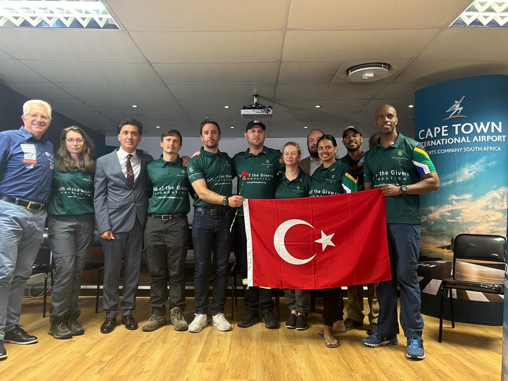 Team members in green shirts holding Turkey flag