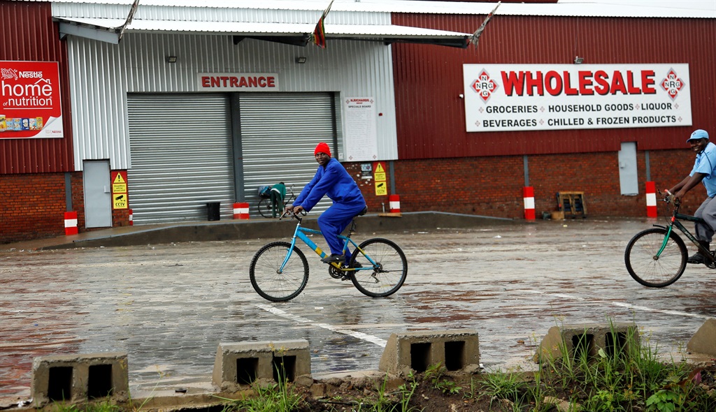 Cyclists pass a wholesale store that was closed amid protests in Harare, Zimbabwe, on Tuesday (January 15 2019). Picture: Philimon Bulawayo/Reuters