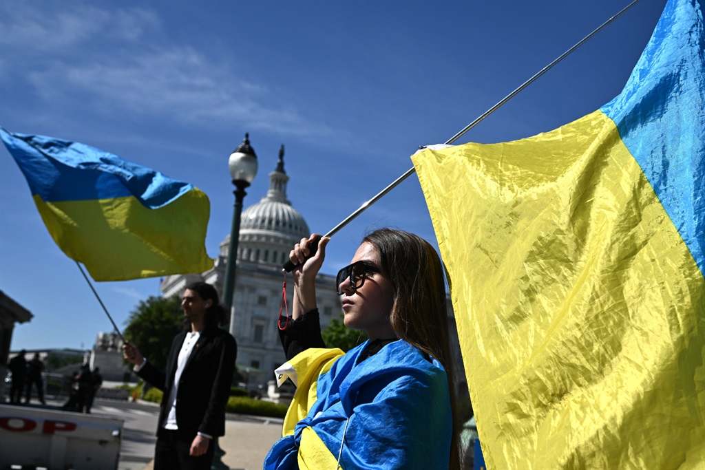 فعالان در 23 آوریل 2024 پرچم های اوکراین را بیرون ساختمان کنگره ایالات متحده در واشنگتن دی سی به اهتزاز در می آورند و منتظر رای گیری در مورد بسته نهایی 95 میلیارد دلاری کمک های خارجی در مجموع کمک های نظامی به متحدان ایالات متحده هستند.  (ماندل نگان/ خبرگزاری فرانسه)
