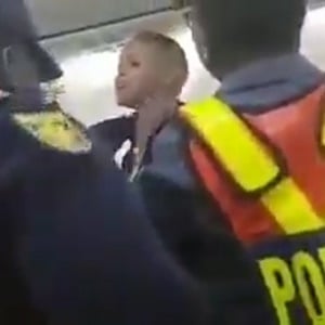 A passenger on a Kulula flight is removed by police. (Screengrab)