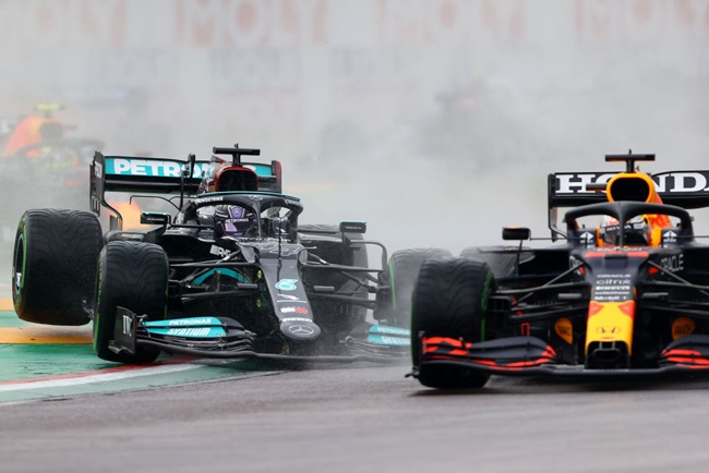 Max Verstappen of the Netherlands driving the (33) Red Bull Racing RB16B Honda and Lewis Hamilton of Great Britain driving the (44) Mercedes AMG Petronas F1 Team Mercedes W12 battle for track position at the start during the F1 Grand Prix of Emilia Romagna at Autodromo Enzo e Dino Ferrari on April 18, 2021 in Imola, Italy. 