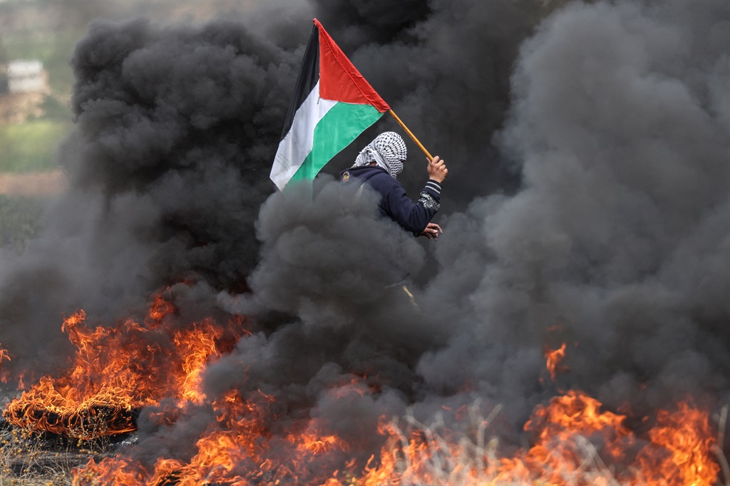 Palestinian youths burn tires during a protest near the Israel-Gaza border east of Jabalia refugee camp, on February 23, 2023. (MAHMUD HAMS / AFP)
